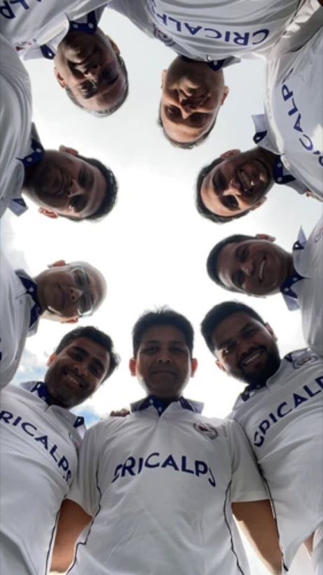 A team huddle photographed from below, players leaning in over the camera