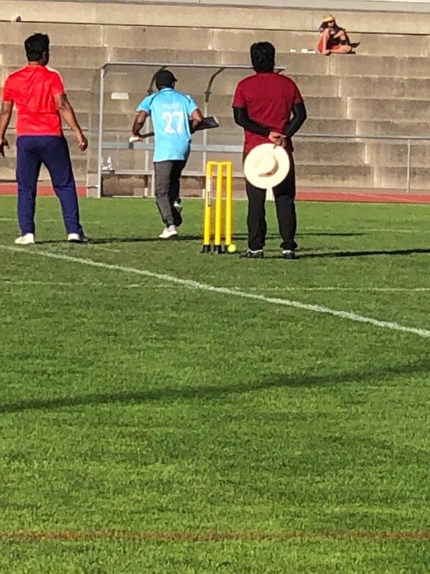 A batter, a keeper and an umpire around the stumps on the artificial pitch