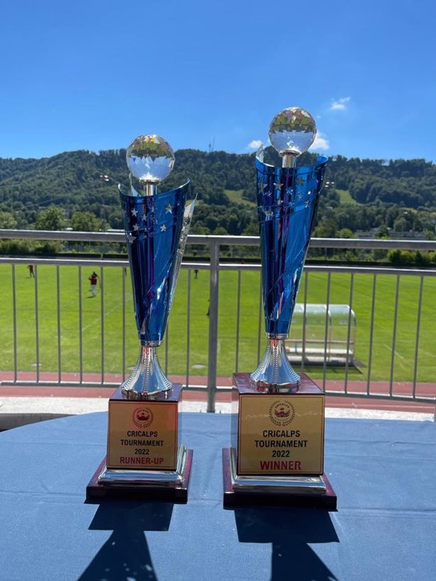 Two tall blue trophies standing against an open sky